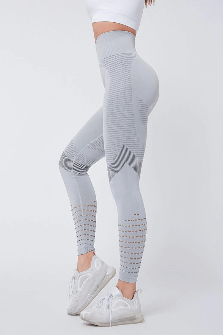 Woman wearing gray high-waisted seamless leggings with a hollow pattern, perfect for fitness and comfort, paired with white sneakers.